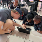 Photo of a young adult working with young children.