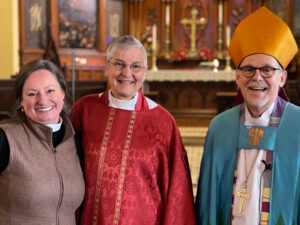 Photograph of Revd Melanie Duguid-May with her wife, Revd. Deborah Duguid-May, and Bishop Steve Lane.